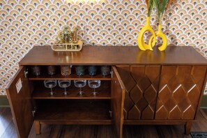 A wooden bar with a wine rack and a pair of yellow scissors on top. - Walk to Mass Ave , Charming 3BR with 2 Kings, Garage & fire pit (Indianapolis)
