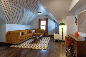 A cozy living room with a brown sofa, a coffee table, and a checkered rug. - Walk to Mass Ave , Charming 3BR with 2 Kings, Garage & fire pit (Indianapolis)
