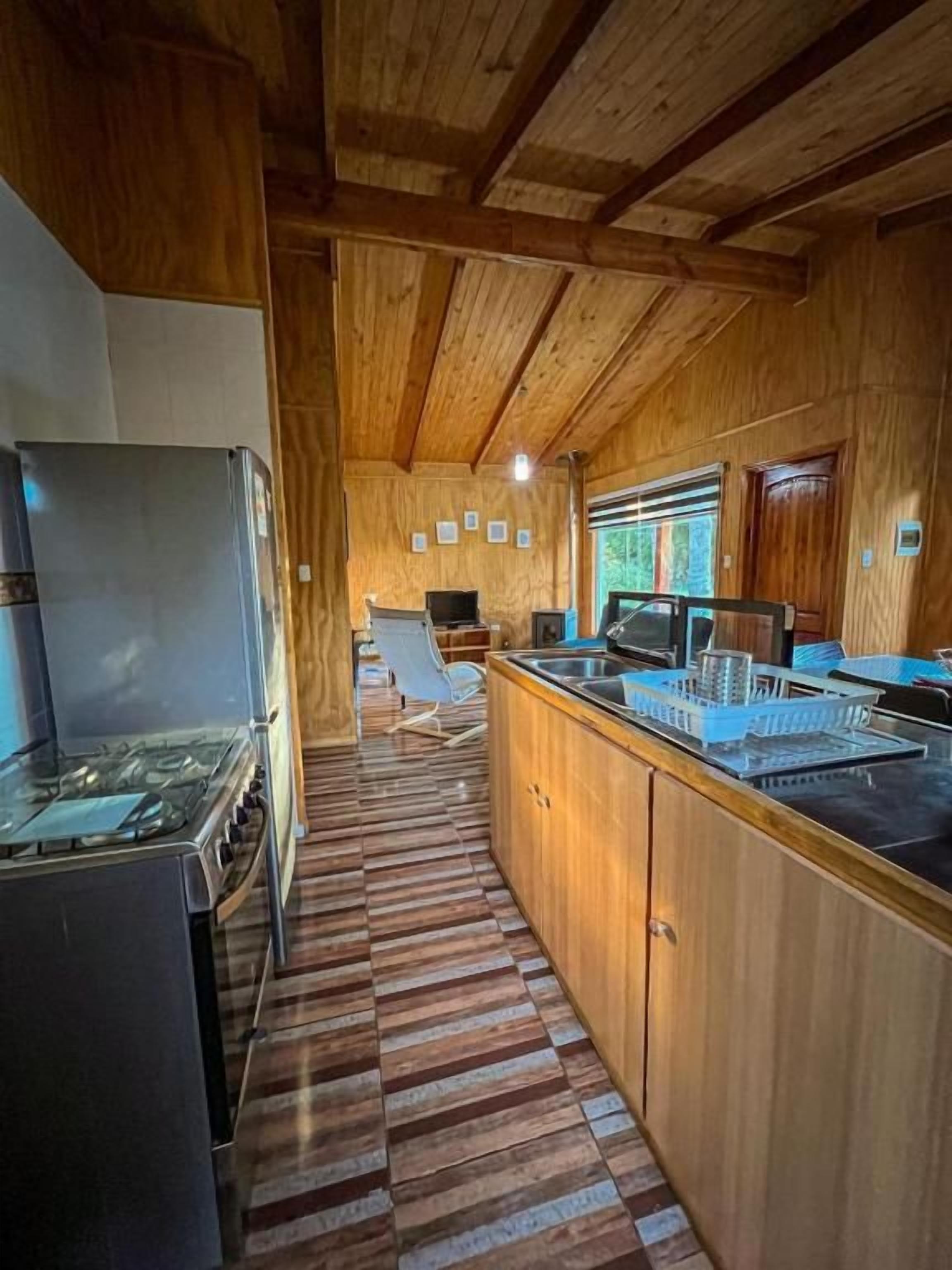 A kitchen with wooden cabinets, a gas stove, and a microwave.