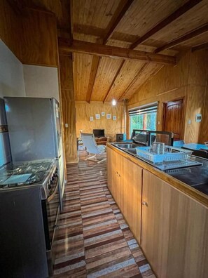 A kitchen with wooden cabinets, a gas stove, and a microwave.
