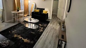 Un espacio habitable compacto con sofá, mesa de centro y zona de comedor.