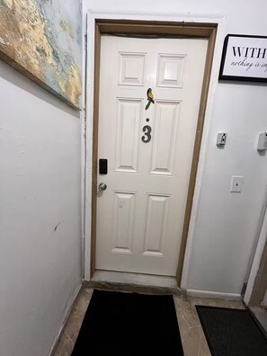 A white door with a bird decoration, a number '3' on it, and a sign above stating 'WITH nothing is impossible.' - Cozy Apartment near Highland Park (Des Moines)