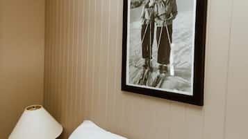 A hotel room with a bed, a framed photograph on the wall, and a bedside lamp.