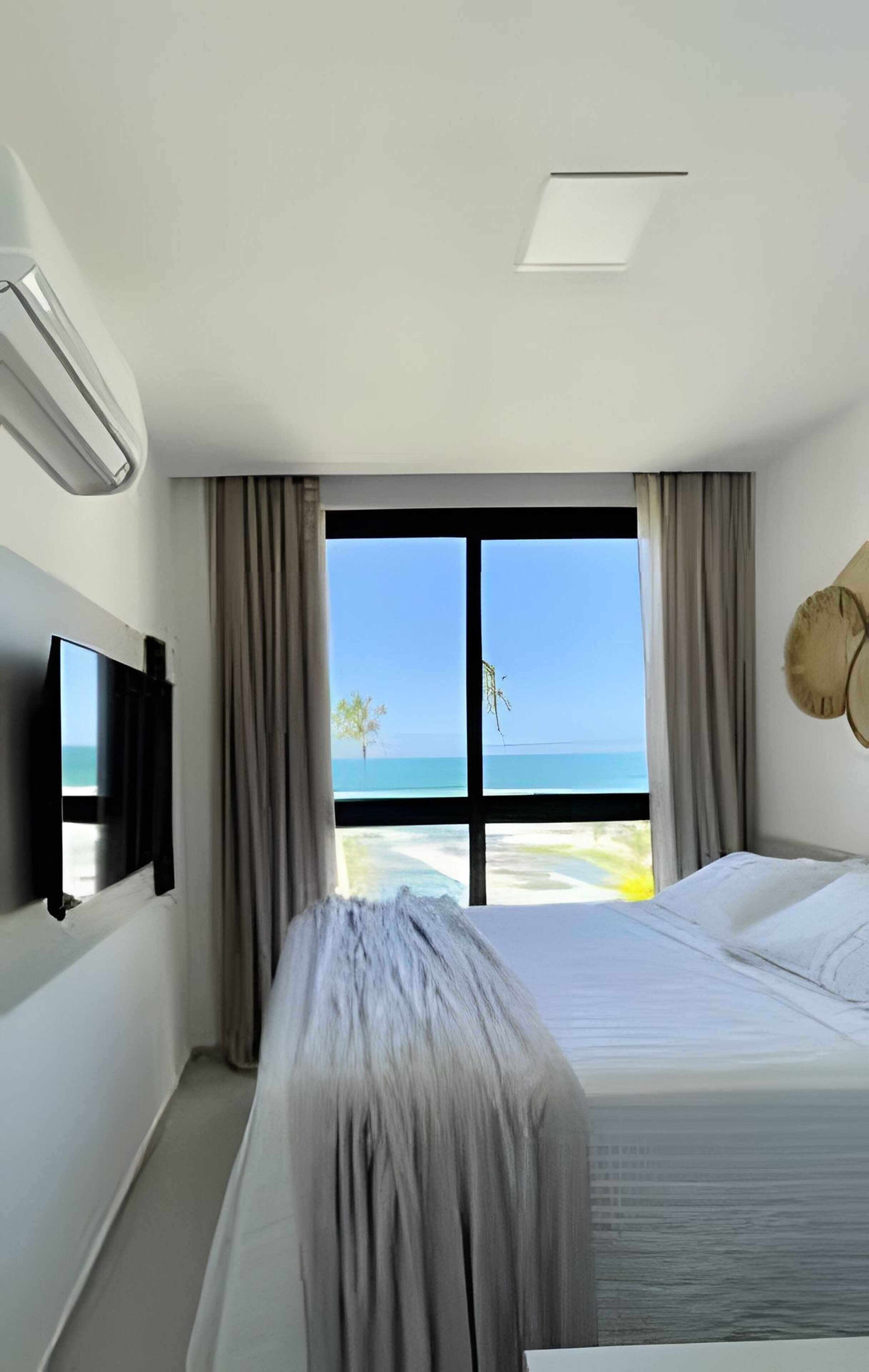 Habitació d'hotel amb un llit, televisió i vista a l'oceà.