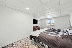 Une chambre à coucher avec un lit, une commode et une fenêtre donnant sur un beau paysage.