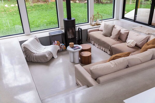 A modern living room with a sofa, a coffee table, and a fireplace.
