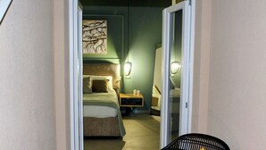 Ett hotellrum med en säng, ett sängbord, en lampa och en stol.