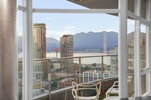 Een balkon met uitzicht op een stadslandschap en bergen.