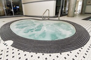 Ein Whirlpool mit Fliesenboden und Metallgeländern.