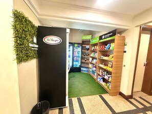 A hotel corridor with a reception area, a Best Market sign, and a Best Market refrigerator. - Fortune Residence (São Paulo)