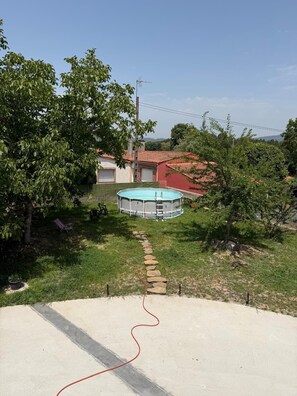 Ein Wohngebiet mit einem Schwimmbad, einem Steinweg und einem Haus mit rotem Dach.