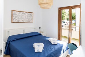 Une chambre d’hôtel avec un lit, une table de chevet, un élément de décoration murale et une vue sur l’extérieur.
