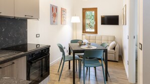 Et moderne køkken med indbygget ovn og spiseplads med bord og stole.