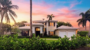 Une maison à deux étages avec une entrée à l’avant, un garage et une pelouse bien entretenue.