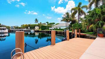 A wooden dock extending over calm water with a clear sky above.
