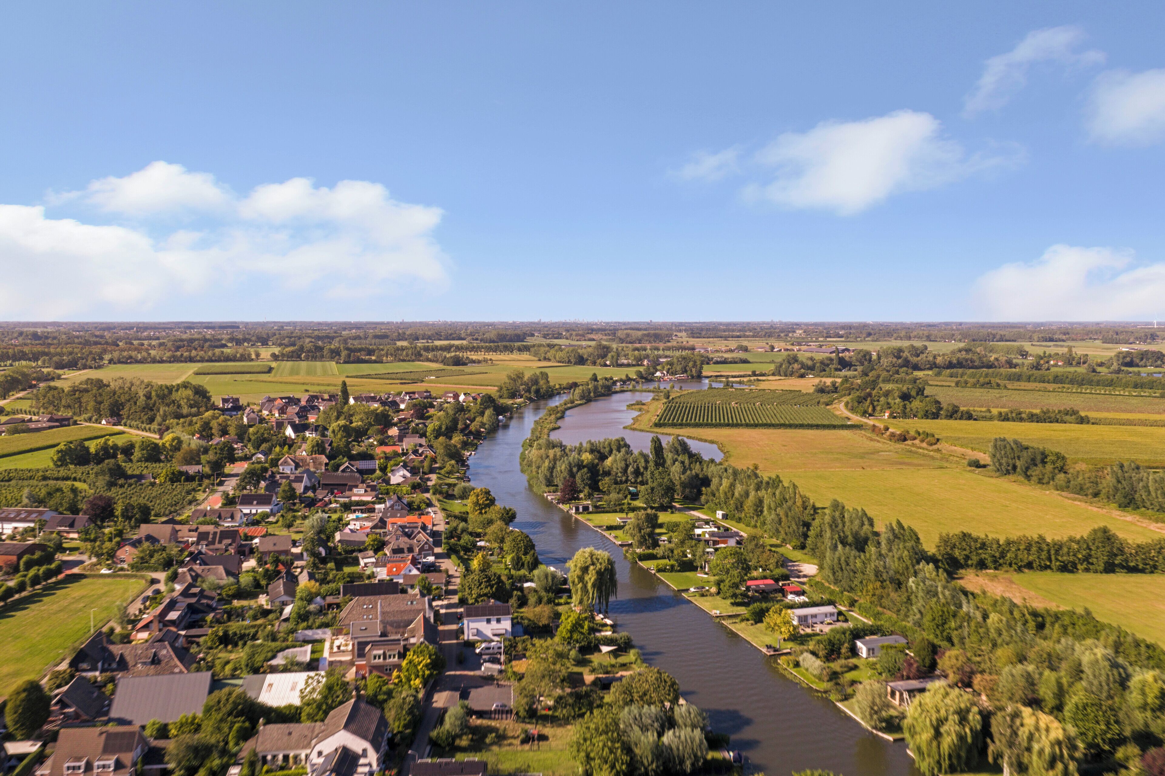 Une rivière traverse une ville, avec des maisons de chaque côté.
