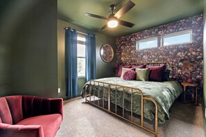 A bedroom with a bed, a chair, a ceiling fan, and a window. - Hot Tub + Fire Pit Yard · Near Fountain Square (Indianapolis)