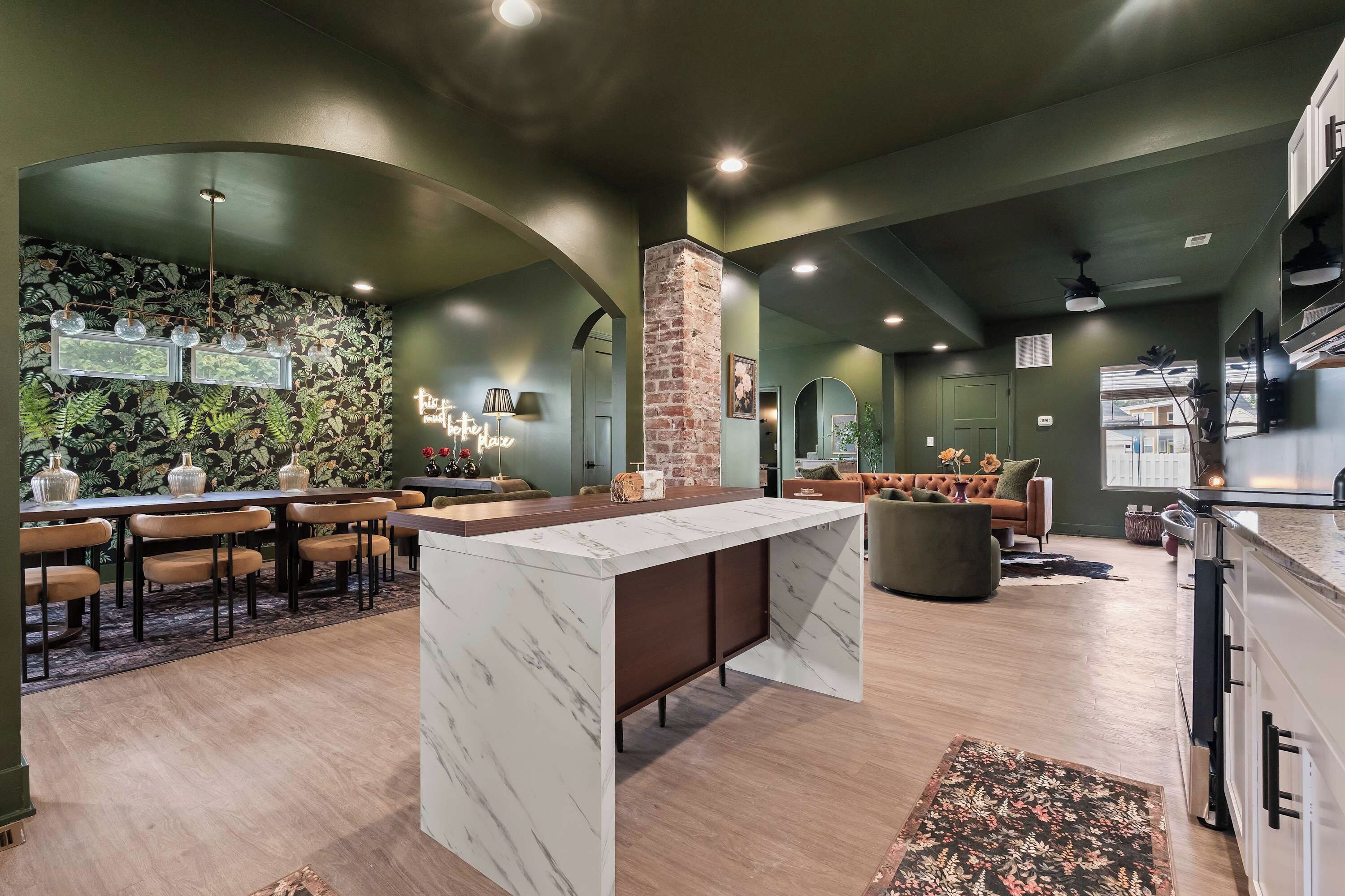 Un intérieur moderne comprenant un bar, des espaces pour s’asseoir et une cuisine.
