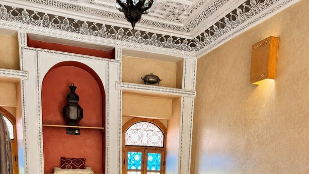 A traditional Moroccan interior with a sofa set, a chess table, and a patterned floor. - Charming 5-Bedroom Mini Riad with Patio, Gym and Inspiring Workspace (Marrakech)