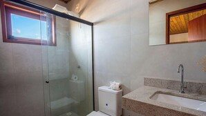A bathroom with a glass-enclosed shower, a toilet, and a sink with a granite countertop. - Apt. w/ Pool & View in Barra Grande Ldi0008 (Maraú)