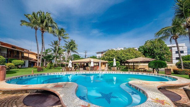A swimming pool with a starfish design, surrounded by palm trees and a tiled deck. - Apt. in Condo. w/ Pool & BBQ Cvc0010 (Camaçari)