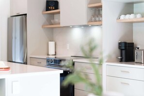 A modern kitchen with a stainless steel refrigerator, a built-in oven, and a coffee machine. - Slo | Luxury, Spa & 2 Saunas Memphremagog lake (Stanstead)