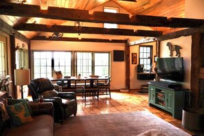 Ein gemütliches Wohnzimmer mit Kamin, Fernseher und Essbereich mit Tisch und Stühlen.