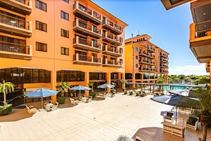 A multi-story hotel with outdoor seating areas, a pool, and balconies. - Studio With Balcony in a Cond. With Pool Jbv0432 (Florianópolis)