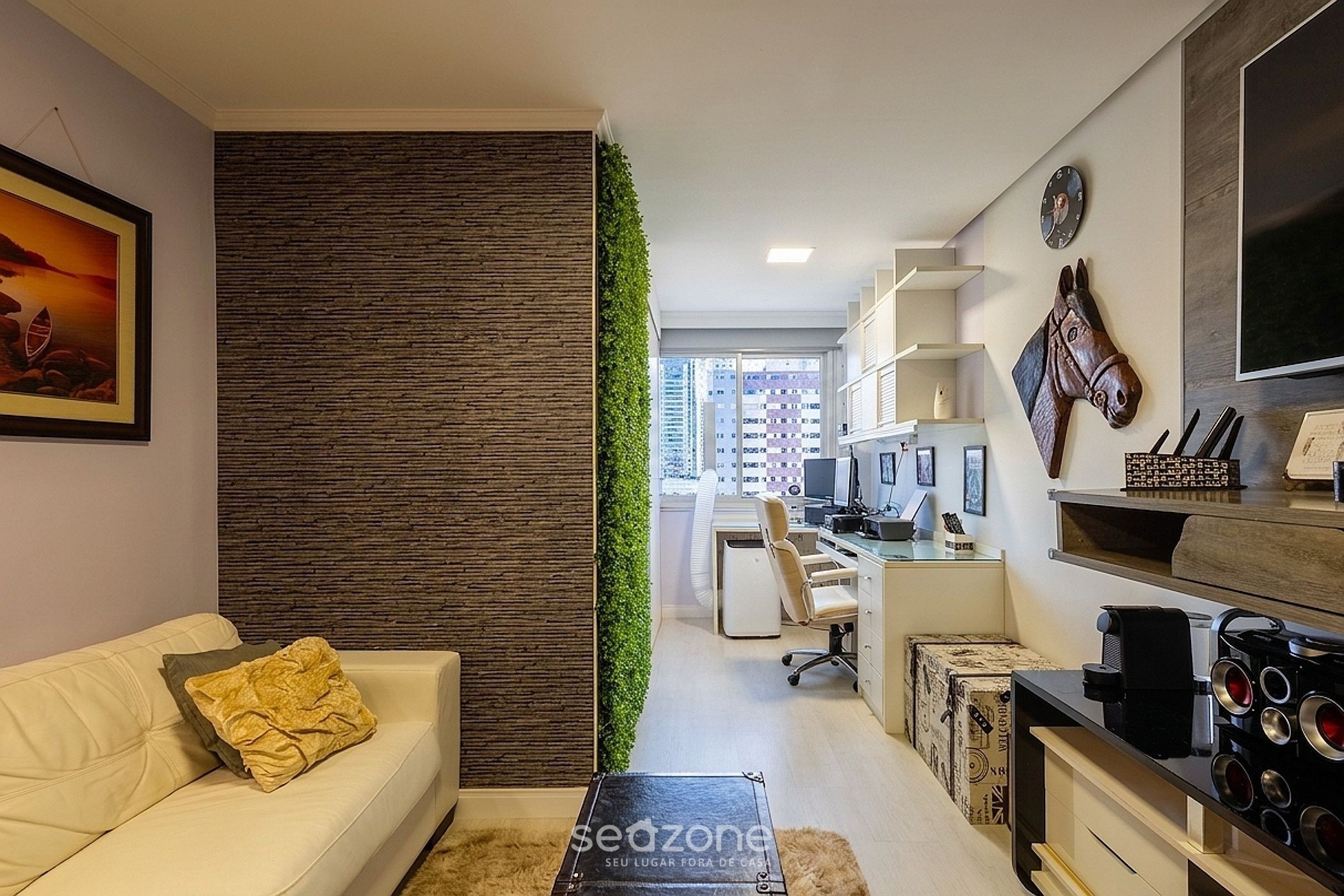 Una sala de estar moderna con un sofá blanco, una mesa de centro y un cojín decorativo.