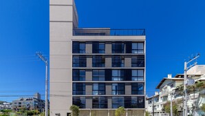 Ein mehrstöckiges Gebäude mit modernem architektonischen Design, das verschiedene Fensterformen und eine markante Eckstruktur aufweist.
