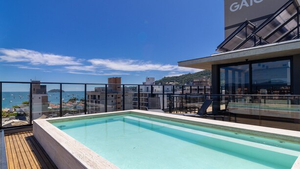 Ein Pool auf dem Dach mit Blick auf das Meer und die Gebäude.