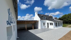 Een wit gebouw met een overdekt terras en een heldere lucht.