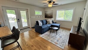 A living room with a sectional sofa, a coffee table, and a TV stand. - Mountain Peace 25 Min from Downtown Asheville (Barnardsville)