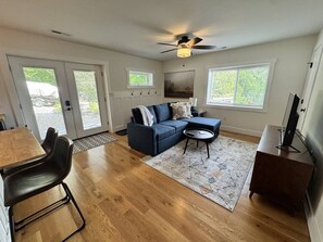 A living room with a sectional sofa, a coffee table, and a TV stand. - Mountain Peace 25 Min from Downtown Asheville (Barnardsville)