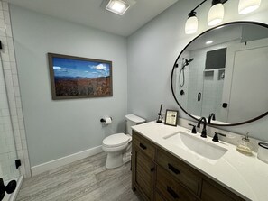 A bathroom with a toilet, sink, vanity, and a large mirror. - Mountain Peace 25 Min from Downtown Asheville (Barnardsville)