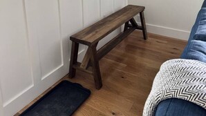 A room with a wooden bench, a window with a view, a coat rack, and a door with a doormat. - Mountain Peace 25 Min from Downtown Asheville (Barnardsville)