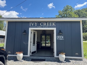 A building labeled 'Ivy Creek Farm Stand' with a door open, two potted plants, and a sign indicating 'Open Always.' - Mountain Peace 25 Min from Downtown Asheville (Barnardsville)