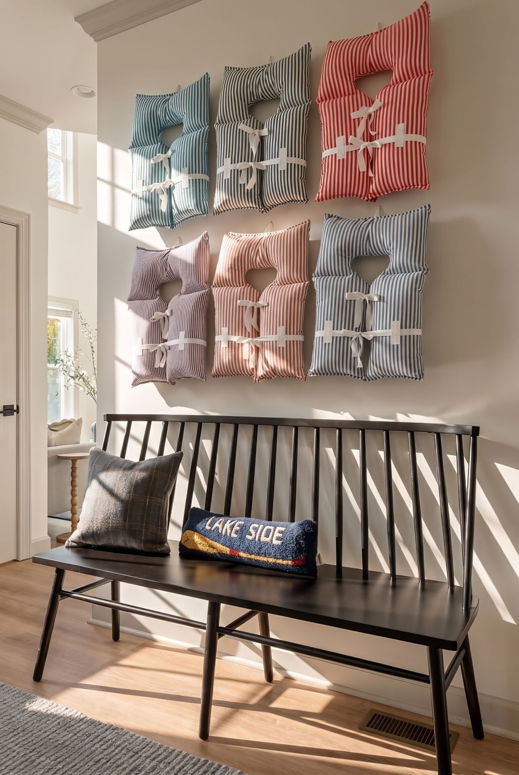 A modern interior with a bench and a wall-mounted pillow display.