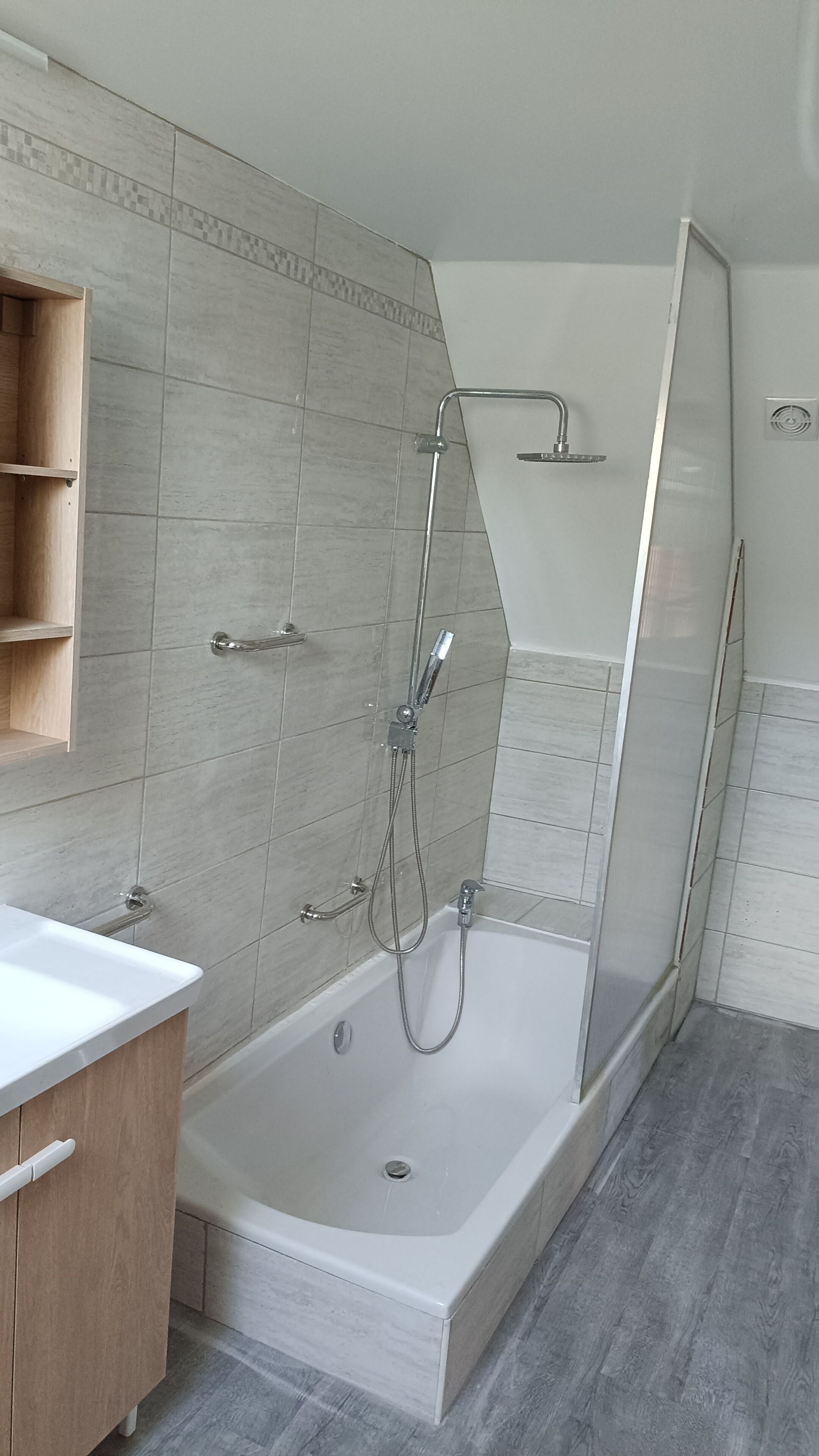 Une salle de bain moderne avec une baignoire, une douche et un meuble-lavabo en bois.