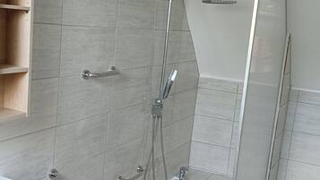 Une salle de bain moderne avec une baignoire, une douche et un meuble-lavabo en bois.