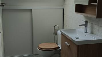 Een badkamer met dakraam, toilet, wastafel en bad.