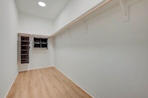 A room with a wooden floor, white walls, and a built-in shelving unit with multiple compartments. - Contemporary Hideaway • PS4 Console & Games • Fire Pit & Turf (North Las Vegas)