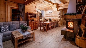 A cozy log cabin interior with a fireplace, wooden furniture, and a dining area. - A Large Mountain-style House With a spa Area (Poronin)