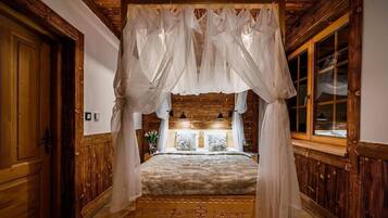 A room with a four-poster bed, wooden walls, and a large window.
