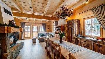 A spacious living area with a fireplace, wooden furniture, and a large window.