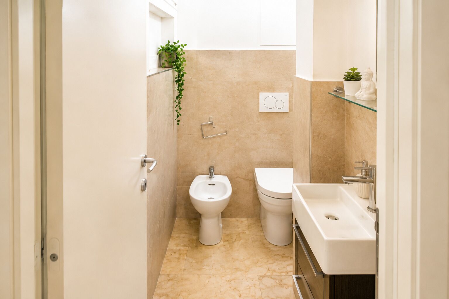 Un baño pequeño con bidé, inodoro y lavamanos.