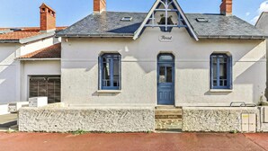 A two-story building with a gabled roof, a blue door, and a nameplate reading 'Rocat'. - Floreal : Villa 1900 au Coeur de St Gilles (Saint-Gilles-Croix-de-Vie)