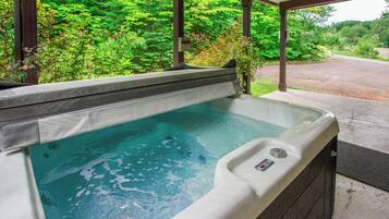 A hot tub with a view of a forested area.