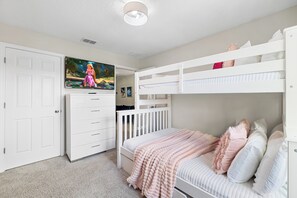 A bedroom with a bunk bed, a TV mounted on the wall, and a white door. - Private Pool •Free Parking •Cozy Solara Resort Home Near Disney •Sleeps 12 Guest (Kissimmee)