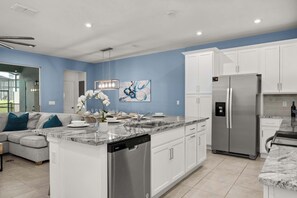 A modern kitchen with white cabinetry, a stainless steel refrigerator, and a marble countertop. - Disney Retreat w/ Private Pool & Resort Access (Kissimmee)